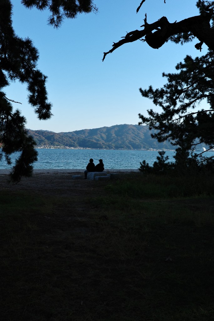 Silhouettes de dos au bord de l'eau - Au gré des continents 